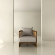 Modern armchair with rattan sides and neutral cushion in minimalist interior design setting