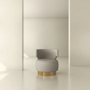Modern beige accent chair with gold base in minimalist interior setting