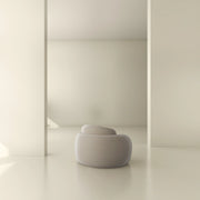 Modern minimalist interior with a sculptural round lounge chair and neutral decor